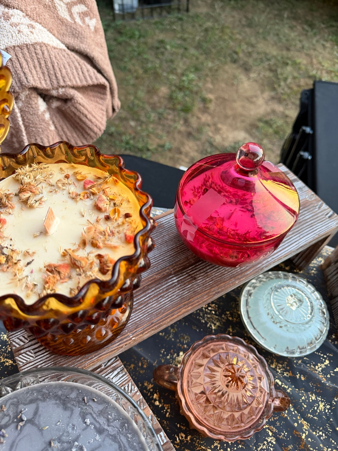 Hand-poured candles in vintage glass on a market table