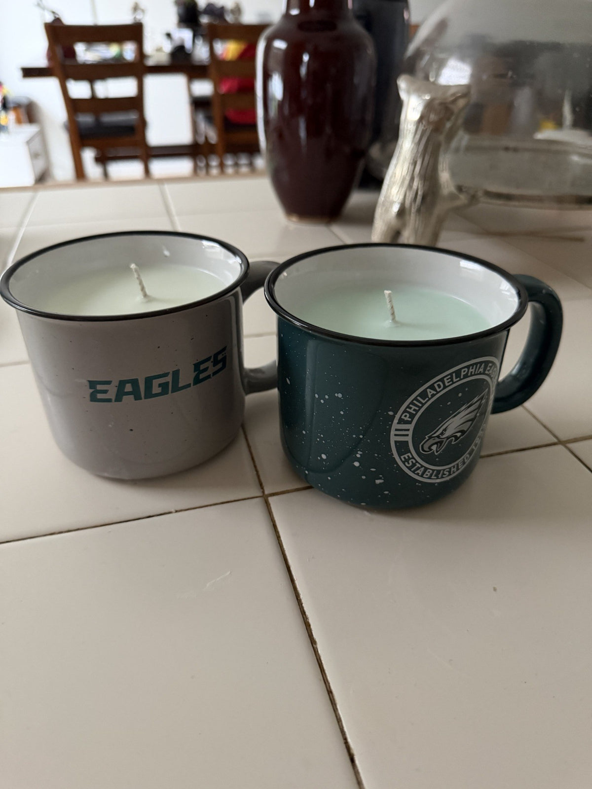 Cream and deep green Eagles mugs filled with pale soy candle wax, sold together as a two-candle set.