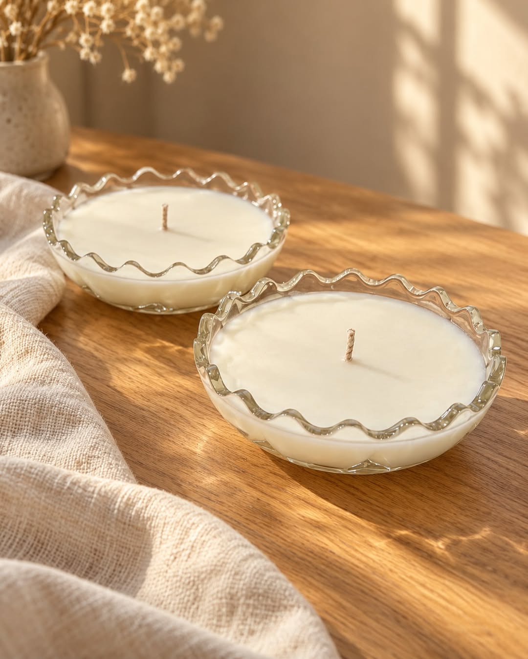 Two matching Honey & Home candles in clear ruffled glass bowls